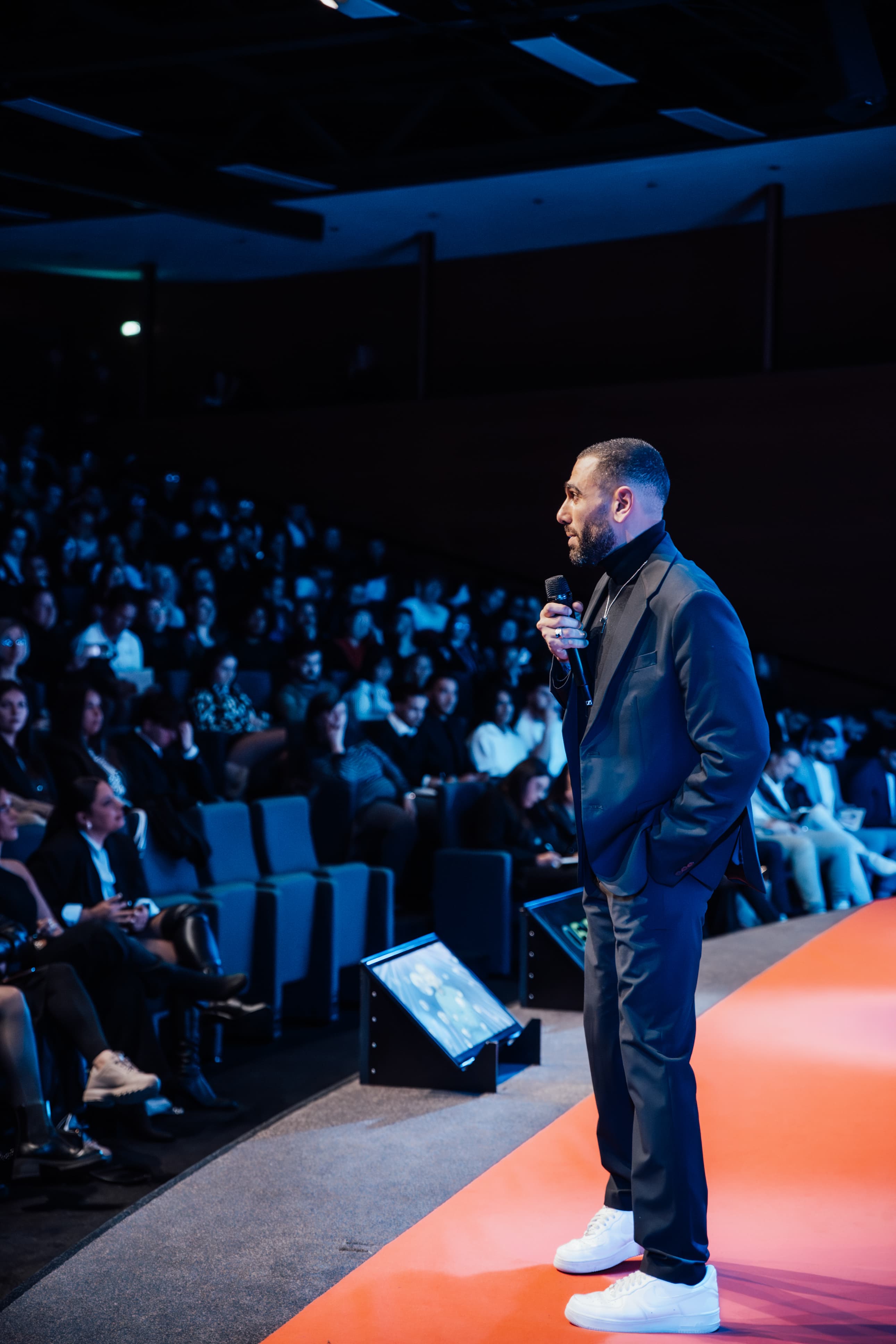 Julien s’adresse à une audience depuis une scène